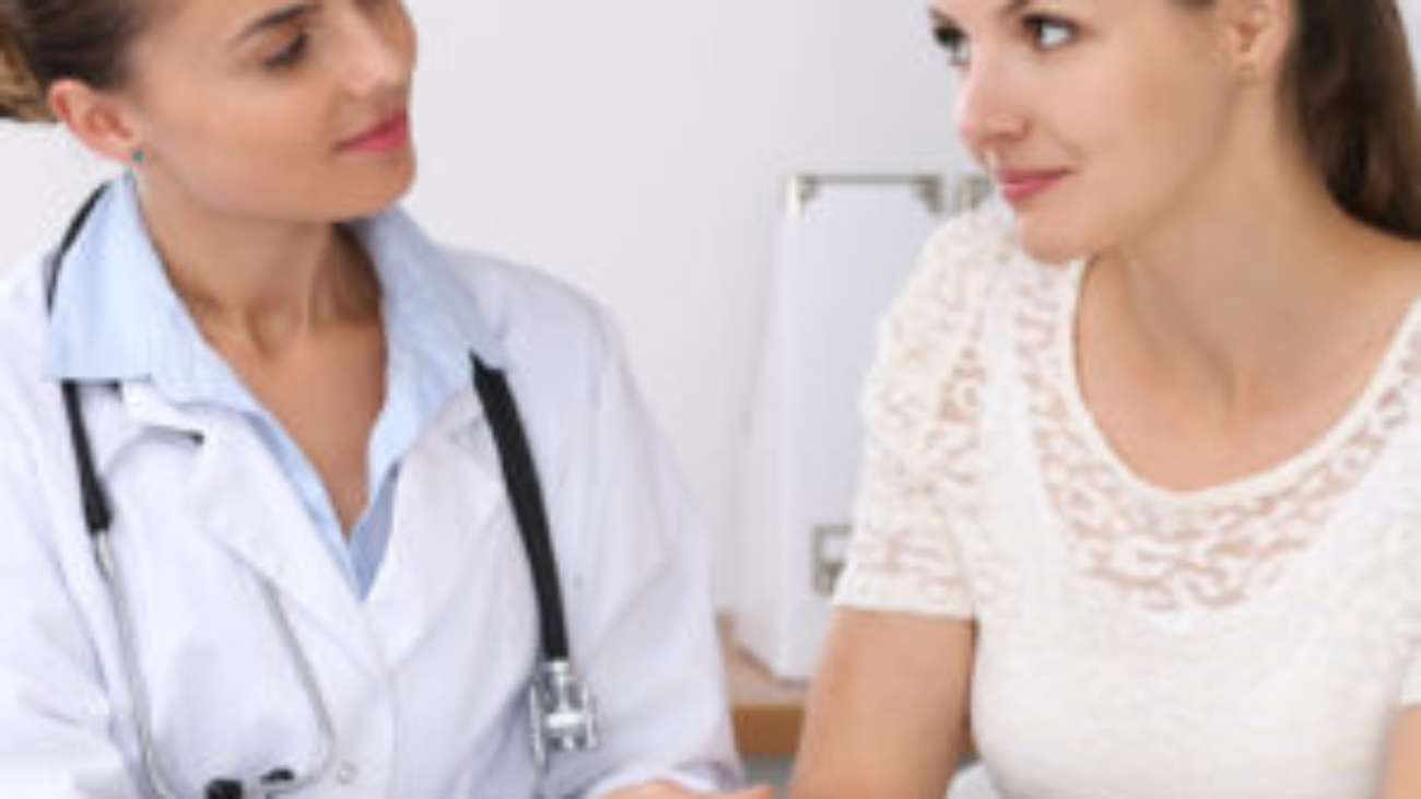 Doctor reassuring her female patient while sitting at the desk. Medicine, help and health care concept.